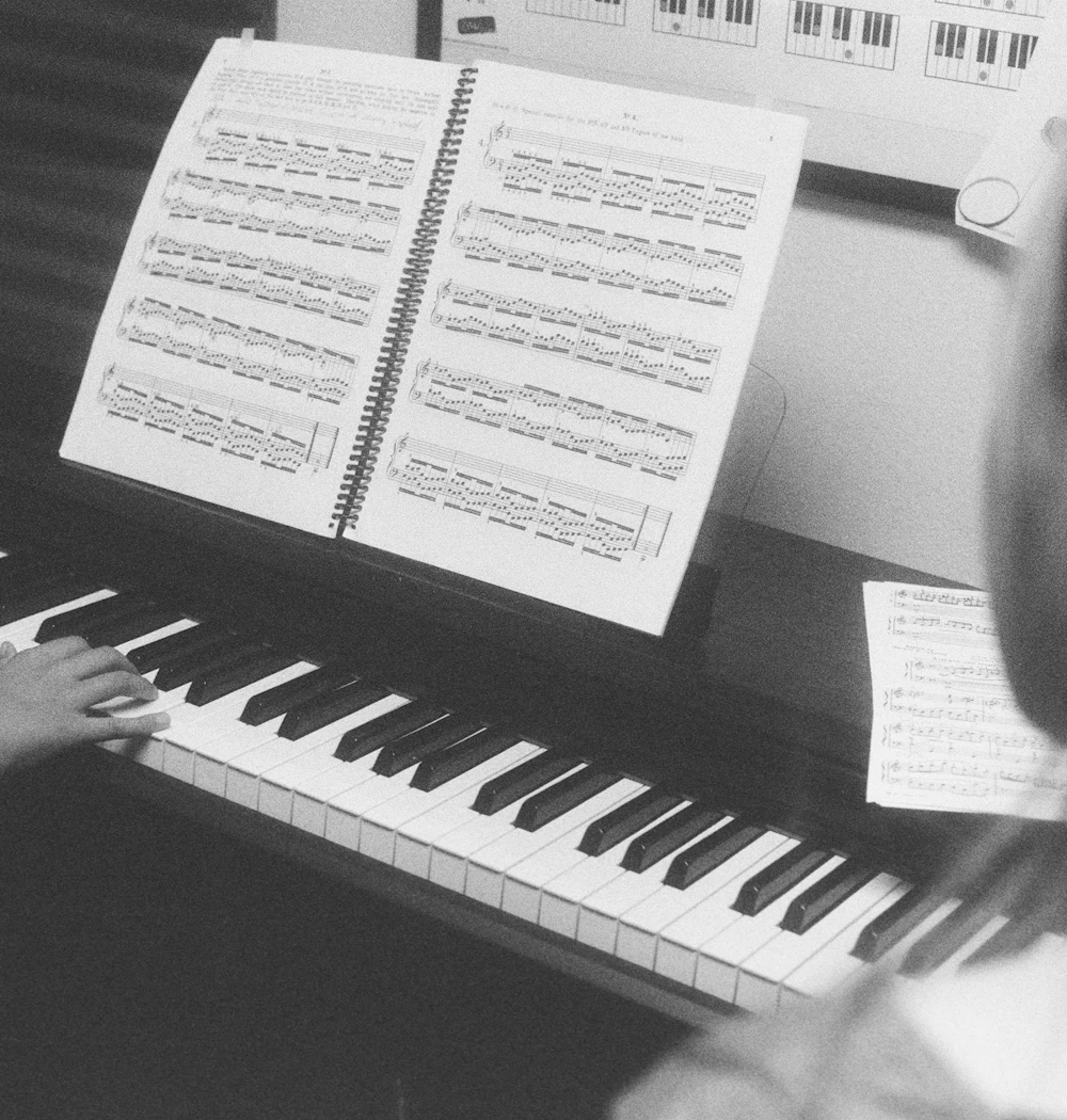 A student playing piano from sheet music